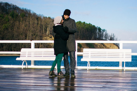 young couple hugs on the pier of the Gdynia embankment on a sunny winter dayの写真素材