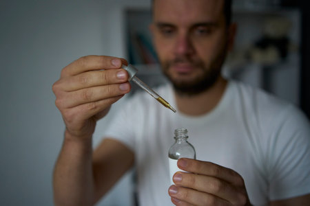 A 30-year-old man applies a beard growth productの写真素材