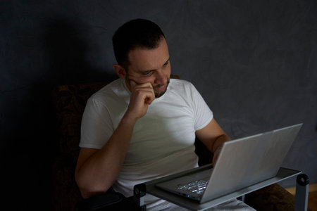 30-year-old man is stressed while working on a laptop from his home officeの写真素材
