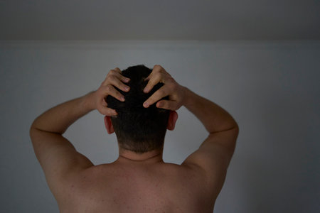 A 30-year-old man is stressed, holding his head with his handsの写真素材
