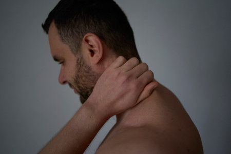 30-year-old man massages his neck to relieve painの写真素材