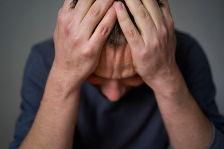 A 30-year-old man is stressed, holding his head with his handsの写真素材