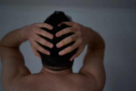 A 30-year-old man is stressed, holding his head with his handsの写真素材