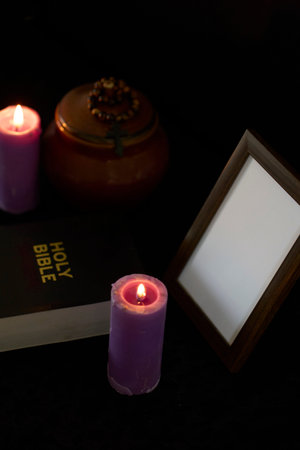 funeral, photo frame, candles,  urn for ashes, holy bible and spiritual bracelet with black cross