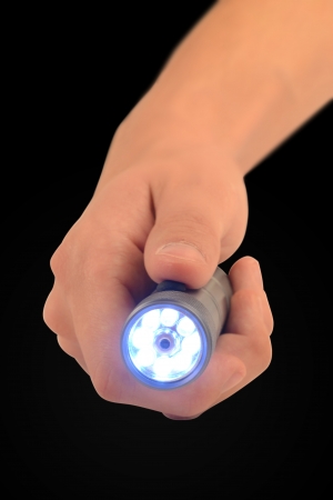 Hand holding a bright led flashlight の写真素材