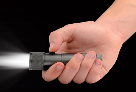 Hand holding a bright led flashlight の写真素材