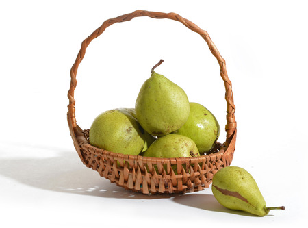 Juicy flavorful pears in basket isolated on whiteの写真素材