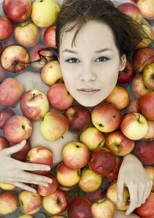 The beautiful girl floating in apples photoの写真素材
