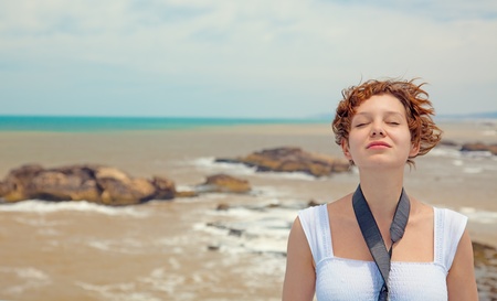 brown-haired young woman, over beautiful sea landscape photoの写真素材
