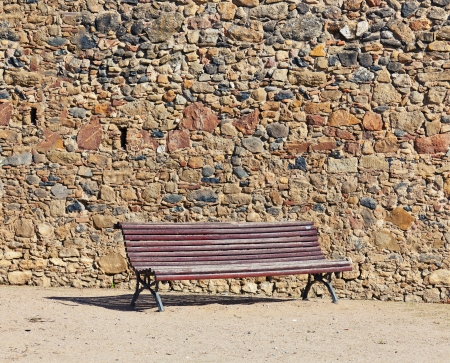 vintage bench near stone wallの写真素材