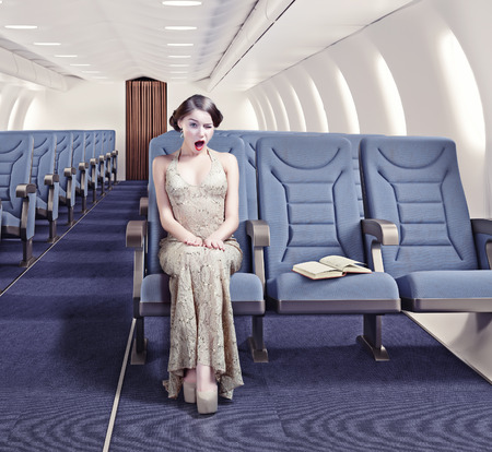 Surprised girl in an airplane. Creative conceptの写真素材