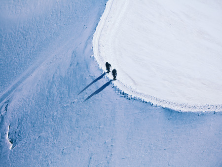 unrecognizable two climbers on the way to a mountain peak in the Alpsの写真素材