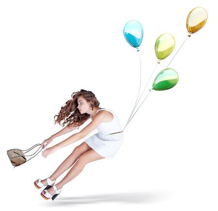 Balloons fly with young beautiful girl. Isolated Creative conceptの写真素材