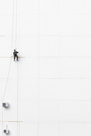 Maintenance worker climbing outside a wallの写真素材