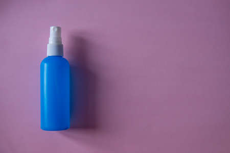 blue hand sanitizer spray on pink backgroundの写真素材