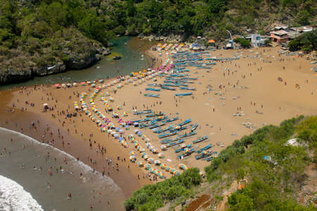 Aerial view of the beach with boats and tourists on a sunny dayの写真素材