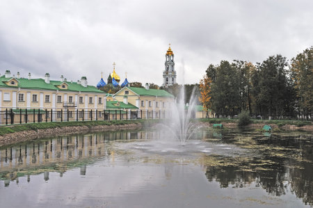 View of monastic pond with fountain in autumn, Sergiev Posad city, Russiaの写真素材