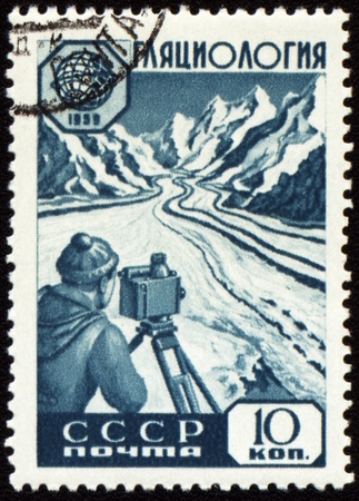 USSR - CIRCA 1959: stamp printed in USSR, shows glaciology researcher with device at glacier in mountain,   circa 1959の写真素材