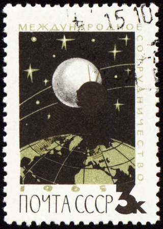 USSR - CIRCA 1965: A stamp printed in USSR shows flight of communication satellite, circa 1965の写真素材