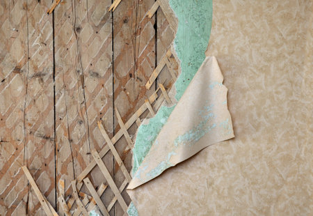 Fragment of old destroyed wall with jagged wallpaper and lath in abandoned houseの写真素材