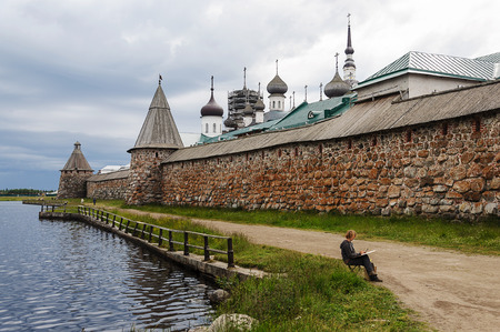 Solovki, Russia, July, 19, 2015. Women artist drowing Spaso-Preobrazhensky Solovetsky monastery in summerのeditorial素材