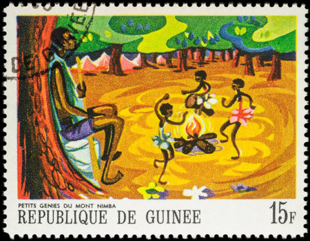 MOSCOW, RUSSIA - MAY 12, 2016: A stamp printed in Guinea shows three little black girls dancing around the fire, series "Paintings of African Legends", circa 1968のeditorial素材