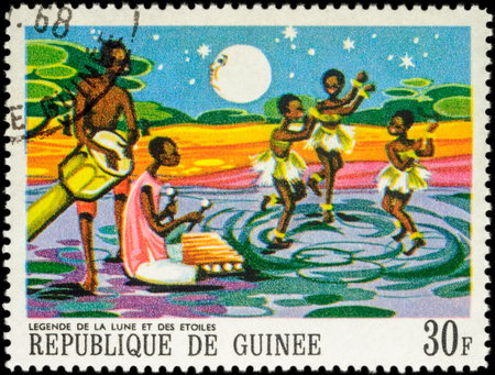 MOSCOW, RUSSIA - MAY 12, 2016: A stamp printed in Guinea shows three dancing black girls - scene from Legend of the moon and the stars, series "Paintings of African Legends", circa 1968のeditorial素材