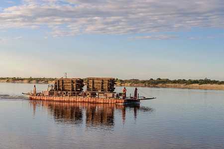 River ferry with timber on the Northern Dvina near Krasnoborsk, Russia. Sunsetの写真素材