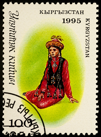 Moscow, Russia - August 07, 2017: A stamp printed in Kyrgyzstan, shows sitting young woman in a traditional Kyrgyz suit, series "Traditional Costumes", circa 1995のeditorial素材