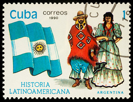 Moscow, Russia - August 09, 2017: A stamp printed in Cuba, shows national flag and a couple in Argentinian traditional costumes, series "Latin-American History", circa 1990のeditorial素材