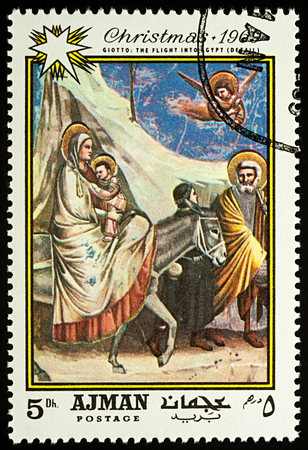 Moscow, Russia - August 20, 2017: A stamp printed in Ajman, shows painting "Flight into Egypt" by Giotto di Bondone (1266-1337), series "Christmas - Paintings", circa 1969のeditorial素材