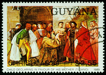 Moscow, Russia - August 24, 2017: A stamp printed in Guyana, shows painting "Child declaring in favour of his Mother" by Titian (1488-1576), series "Christmas - Paintings", circa 1989のeditorial素材