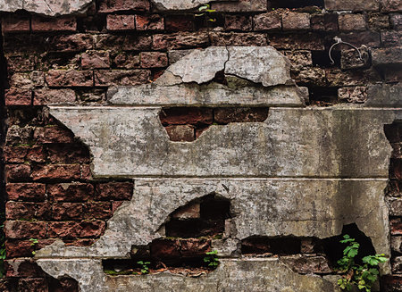 Texture of an old red brick wall with damaged plaster