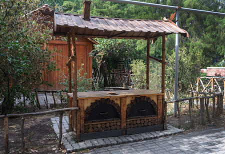 Beautiful wooden table with tent for preparing shashlik in park of Yerevan, sunny autumn dayの写真素材