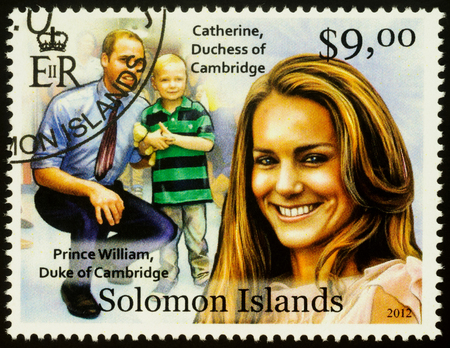 Moscow, Russia - October 21, 2019: A stamp printed in Solomon Islands shows Prince William, Duke of Cambridge and Catherine, Dushess of Cambridge with son, series "Royal Charity", circa 2012のeditorial素材