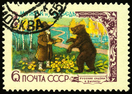 Moscow, Russia - May 08, 2020: stamp printed in USSR (Russia), shows peasant and bear, series Russian Fairy Tales, circa 1961のeditorial素材