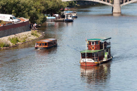 Prague, Czech Republic - July 23, 2019: Old pleasure boats with tourists on Vltava River in center of Prague, next to Charles Bridgeのeditorial素材