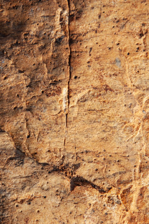 Texture of rough cracked brown stone surface