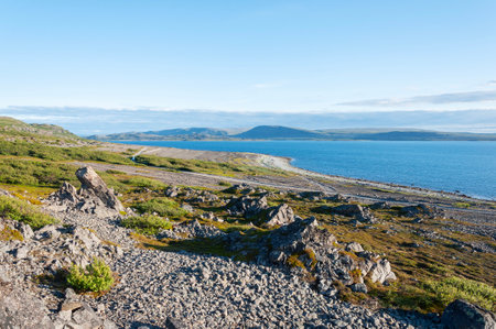 Rocky mountainside at the shore of the Barents Sea, sunny day. Rybachy peninsula, Murmansk region, Russiaの写真素材