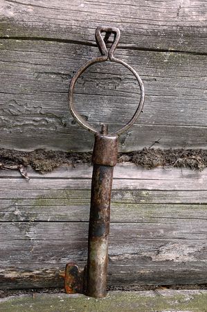 Old forged key on the wall of the log-house in the Russian village.の写真素材