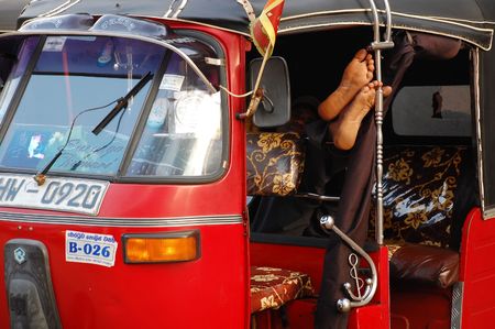 Three-wheeler driver is taking a nap while waiting for passengers near shopping center in Colombo (Sri lanka)のeditorial素材