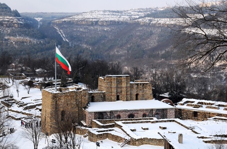 National Bulgarian flag is waving over medieval Tsarevets stronghold in the city of Veliko Tarnovo in Bulgaria in the winterの写真素材