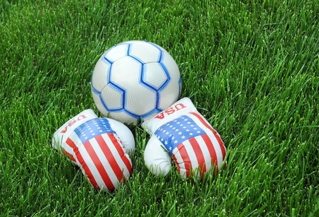 Boxing gloves with US flag image and soccer ball on the green lawnの写真素材