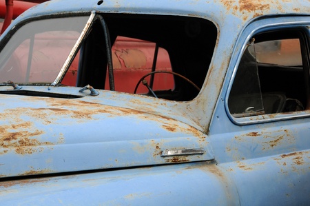 Close-up abandoned rusty blue car in the scrapeyard のeditorial素材