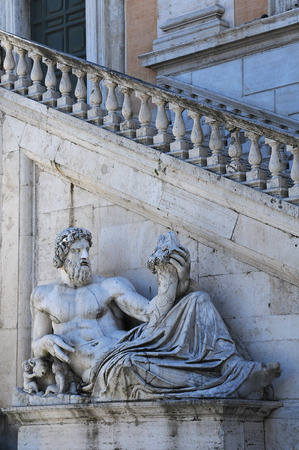 Ancient statue of the Tiber river god in front of the Senatorial Palace staircase on the Capitoline Hill in Rome, Italyの写真素材