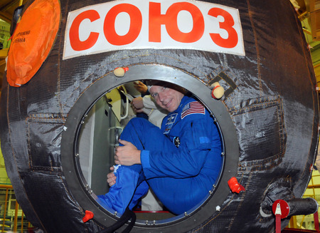 BAIKONUR, KAZAKHSTAN - NOVEMBER 12, 2014: ISS Expedition 42-43 NASA flight engineer Terry Virts looks out from the hatch of the Russian Soyuz TMA-15M spacecraft during fit check at Baikonur Cosmodromeのeditorial素材