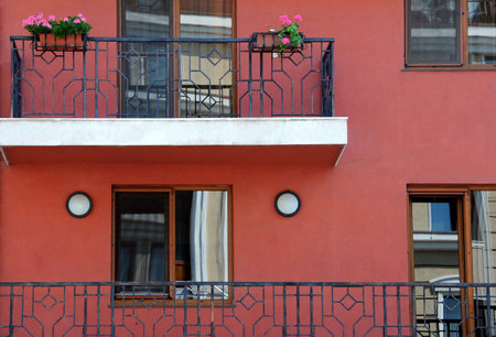 Closeup red stone building with balconies and windowsの写真素材
