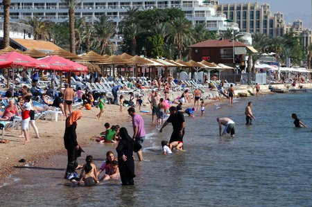 EILAT, ISRAEL ,NOVEMBER 18, 2010: Men, women and kids relax on the beachのeditorial素材