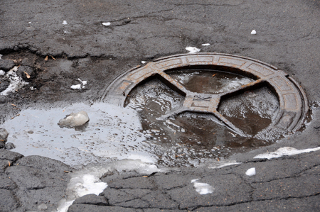 MOSCOW, RUSSIA - FEBRUARY 23, 2016: Sanitary sewer manhole in bad condition on the road in the winterのeditorial素材