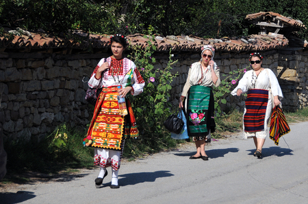 ARBANASI VILLAGE, BULGARIA - JULY 22, 2016: Bulgarian women wearing traditional Bulgarian costumes walk down the streetのeditorial素材